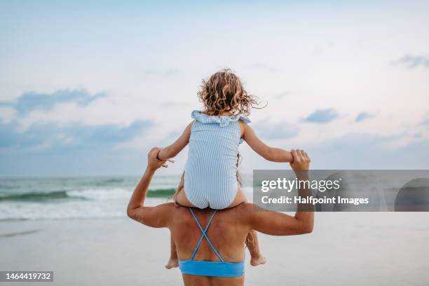 mother holding her daughter piggyback. - piggyback stock pictures, royalty-free photos & images