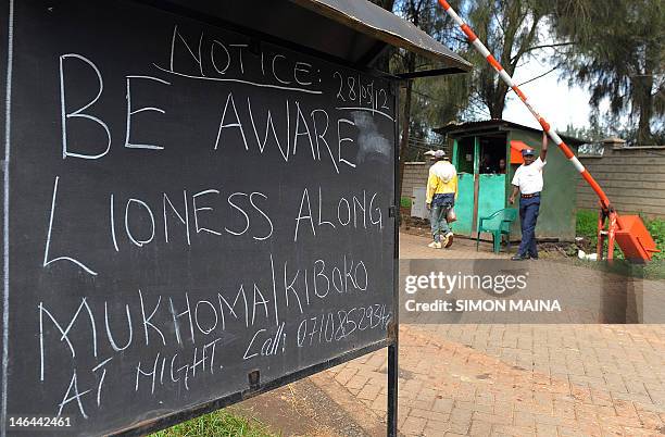 Guard stands guard next to a notice put up on June 8, 2012 outside the main entrance of residential houses in Karen, Nairobi's upmarket area. The...