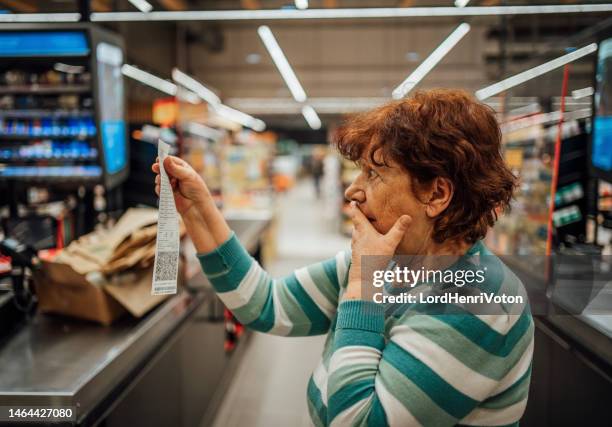 senior woman feeling shocked because of the high amount on the bill - shopping disappointment stock pictures, royalty-free photos & images