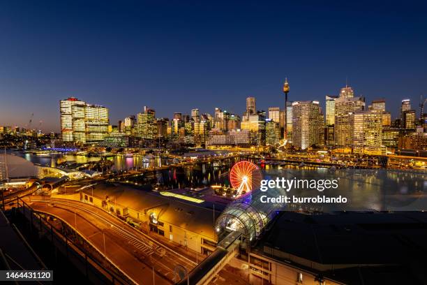 the lights come on the buildings in sydney's skyscrapers during the blue hour as the sun sets - darling harbour stock pictures, royalty-free photos & images
