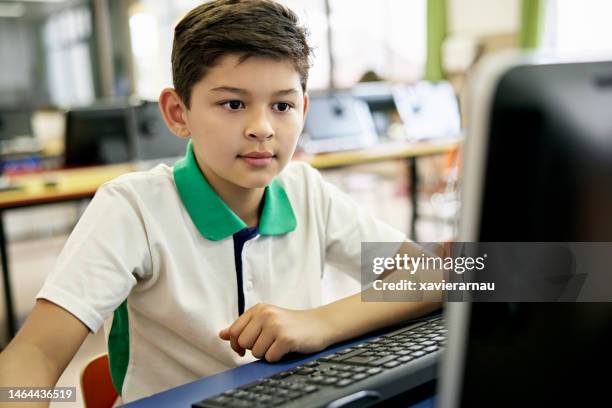 young boy using computer at school - private school boy stock pictures, royalty-free photos & images