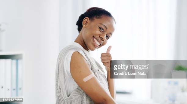 black woman, thumbs up for vaccine and smile with bandage from healthcare in medical consultation. thank you, ok and happy with medicine, patient in doctor office and  health portrait on mockup space - medical thank you imagens e fotografias de stock