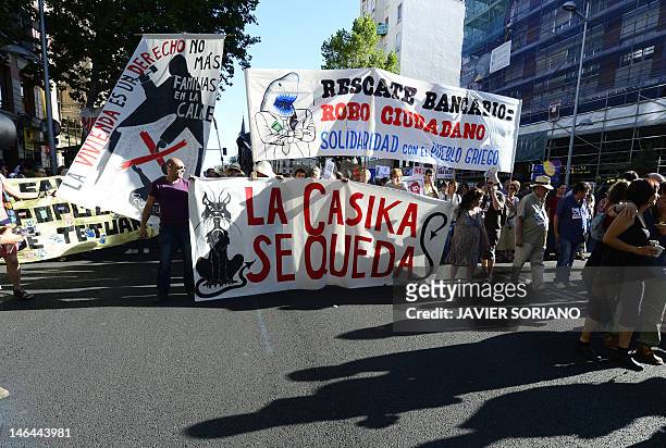 People holding a banner reading "Bank bailout: a citizen robbery" attend a demonstration against bank fraud on June 16, 2012 in Madrid. Spain's...