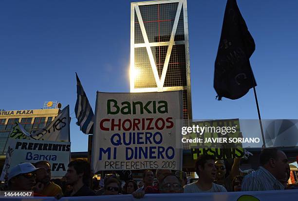 People holds a placard reading "Bankia thieves, i want my money back" during a demonstration against bank fraud on June 16, 2012 in front of Spanish...