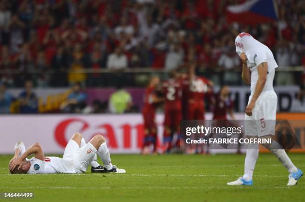 Polish defender Damien Perquis and Polish midfielder Dariusz Dudka react as Czech players celebrate after winning the Euro 2012 championships...