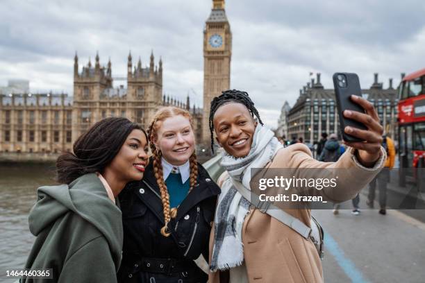 junger multiethnischer tourist in london mit smartphone, um selfies zu machen - big ben black and white stock-fotos und bilder