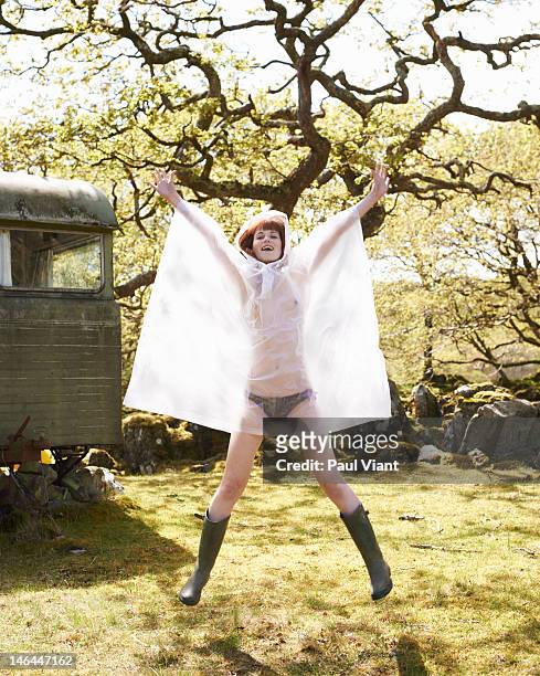 young woman jumping in waterproof coat - see through knickers stock pictures, royalty-free photos & images