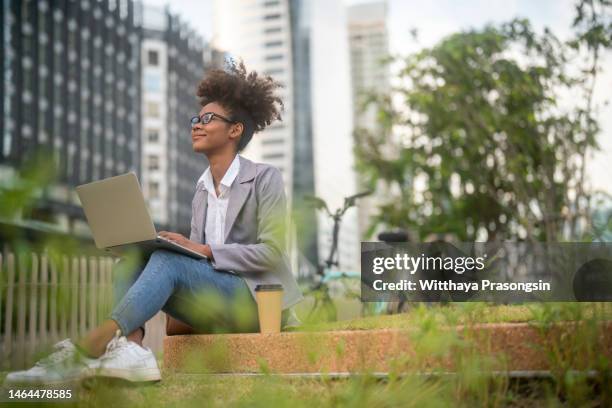 latina college girl looking - student girl using laptop computer and smart phone stock-fotos und bilder