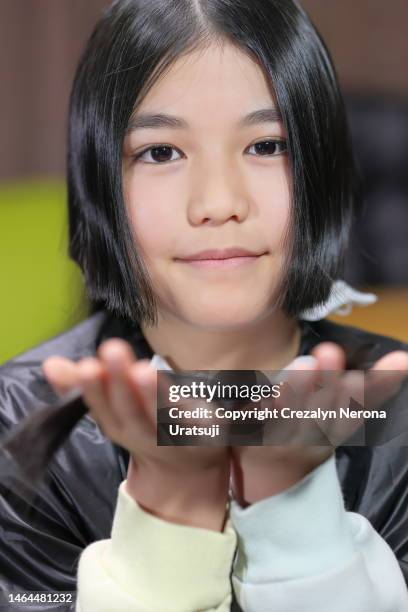 child showing her trimmed hair,looking at the camera,smiling cute - girl hold nose stock pictures, royalty-free photos & images