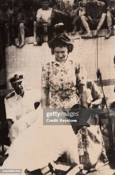 British Royal George VI watches his daughter, Princess Elizabeth, during the traditional 'Crossing the Line' ceremony aboard HMS Vanguard, location...