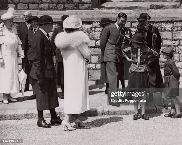 British Royals Princess Elizabeth and her sister, Princess Margaret, both wearing Girl Guides uniforms, alongside their parents, King George VI and...