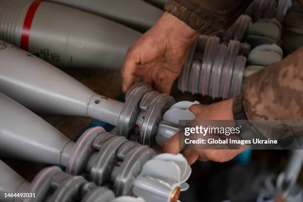 Ukrainian soldier prepares the mortar rounds equipping them with semicircular plastic boxes with gunpowder on January 2, 2023 in Donetsk Oblast,...