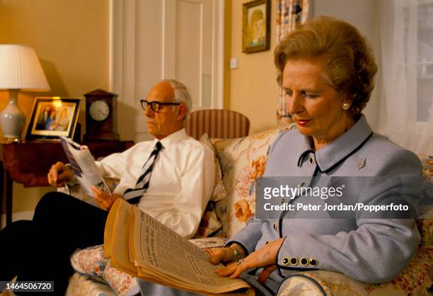 Conservative Party politician and Prime Minister of the United Kingdom Margaret Thatcher seated on a sofa with her husband Denis Thatcher in an...