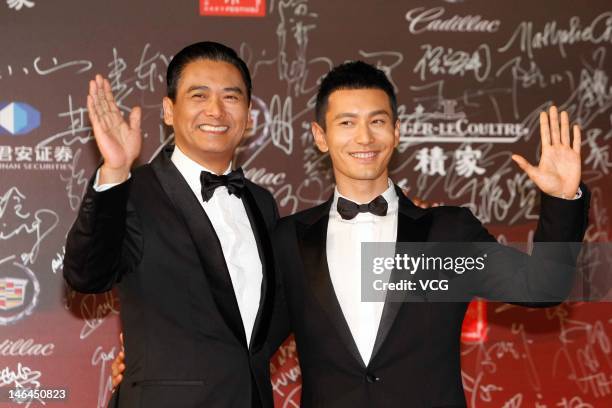 Actors Chow Yun Fat and Huang Xiaoming arrive at the red carpet during the opening ceremony for the 15th Shanghai International Film Festival at...