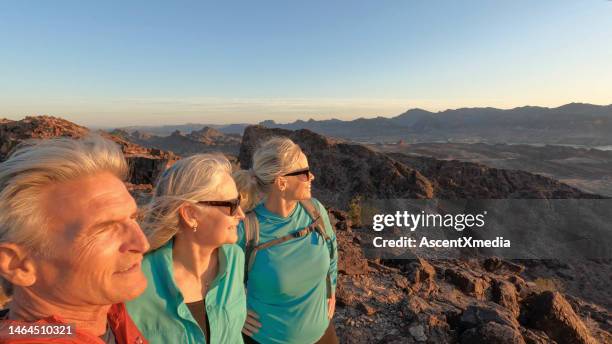mature hikers look off from mountain summit - epic rock stock pictures, royalty-free photos & images