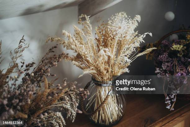 dried wheat and wildflowers in glass jars. - fiori appassiti foto e immagini stock