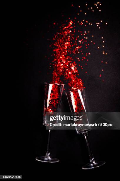 two glasses with red confetti on black background,flat lay top view - top lay wine stock-fotos und bilder