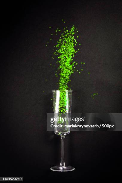 glass with green glitter on black background,flat lay top view - top lay wine stock-fotos und bilder