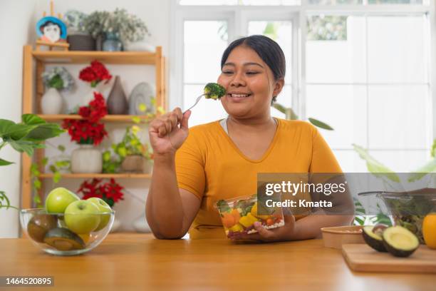 plus size woman eating salad. - eating fiber stock pictures, royalty-free photos & images