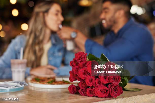 date, roses and couple at a restaurant for valentines day, celebration and anniversary. romance, love and table with flowers, man and woman eating and dinner at a luxury diner for fine dining - day anniversary stock pictures, royalty-free photos & images