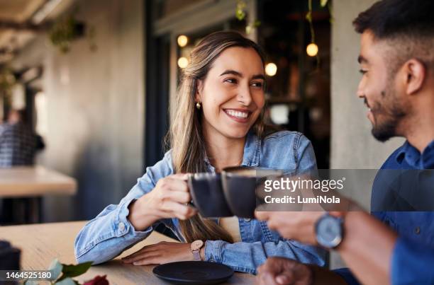 cafe, couple date cheers and woman smile in a coffee shop with a man feeling love and happiness. restaurant, discussion and happy people out for lunch talking about relationship with morning drink - coffee shop couple stock pictures, royalty-free photos & images