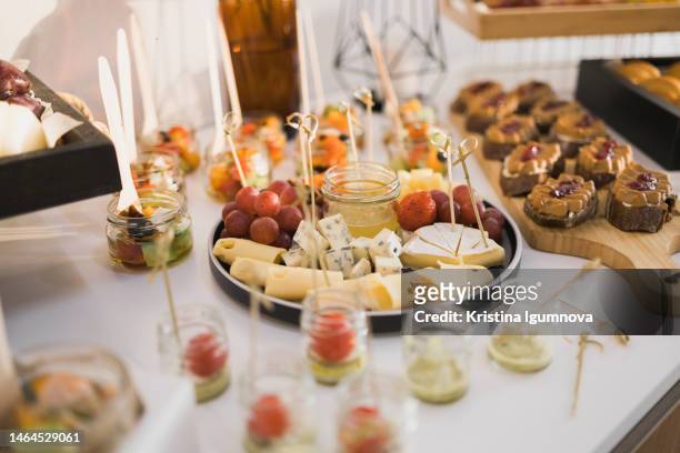 beautifully decorated catering banquet table with different food snacks and appetizers on corporate christmas birthday party event or wedding celebration - food and drink industry stock pictures, royalty-free photos & images