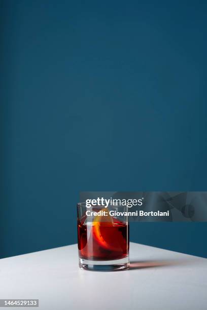 negroni cocktail on white table - speakeasy stock-fotos und bilder