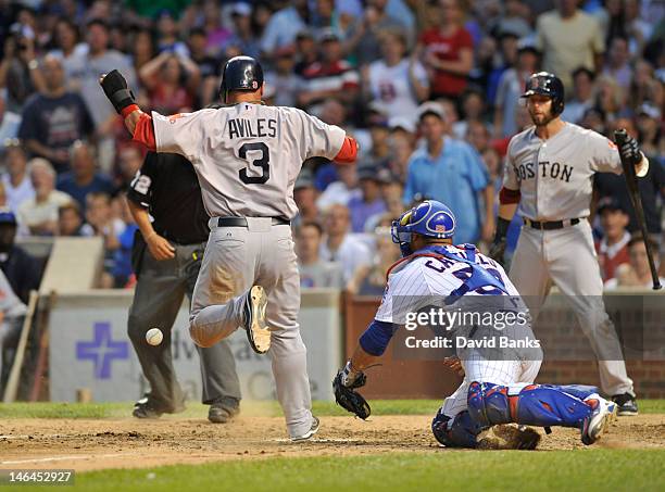 Mike Aviles of the Boston Red Sox scores as Welington Castillo of the Chicago Cubs takes the throw in the seventh inning on June 16, 2012 at Wrigley...