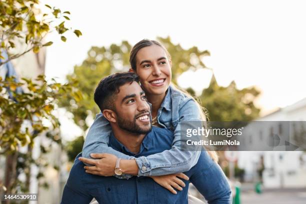 travel, piggyback and happy couple with love in the city on a walk while on a romantic date. happiness, smile and young man and woman having fun, walking and bonding in the town street on a vacation. - lovers stock pictures, royalty-free photos & images