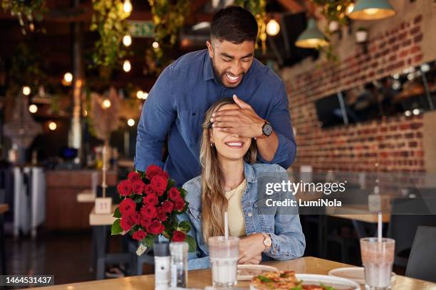 flowers, surprise and love couple at restaurant with bouquet of roses to celebrate anniversary, valentines or birthday. cafe, romance diversity and happy man cover eyes of woman for floral rose gift. - 21 & over stock pictures, royalty-free photos & images