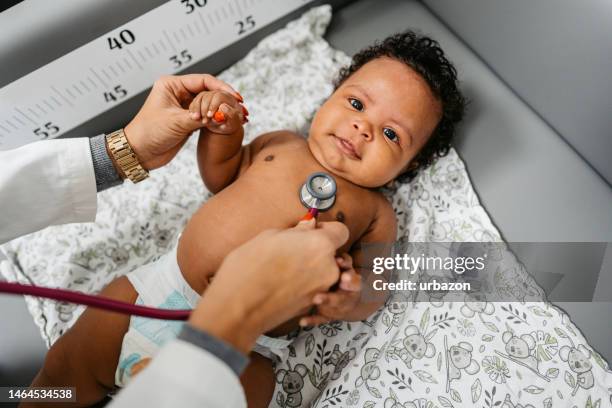 female pediatrician auscultating a newborn baby - pediatric nurse stock pictures, royalty-free photos & images