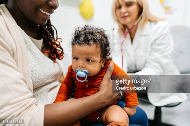 kinderärztin bei der auskultation eines neugeborenen babys - pediatric nurse stock-fotos und bilder