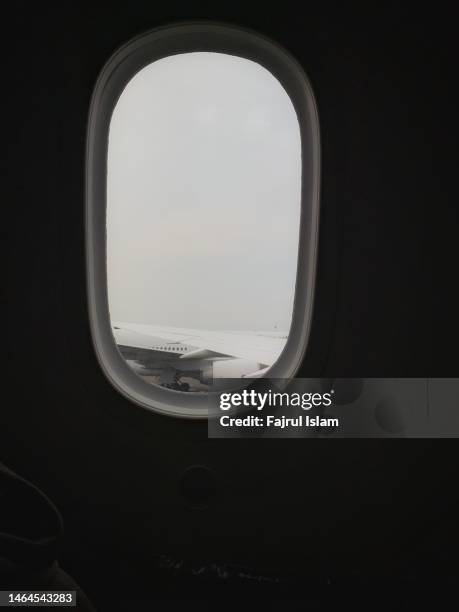 airplane wing photographed from inside the window - jet black wings stock pictures, royalty-free photos & images