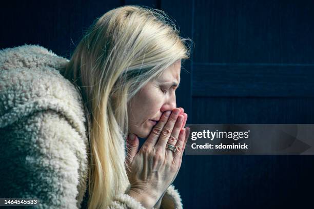 middle aged woman in tearful prayer - prayer solitude stock pictures, royalty-free photos & images