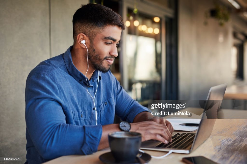 Mann, Kopfhörer oder Laptop tippen in Café oder Restaurant für Universität, College oder Schule lernen mit Lern-Podcast-App. Studenten-, Technik- oder Bildungsmusik für Studienforschung auf einem abgelegenen Campus