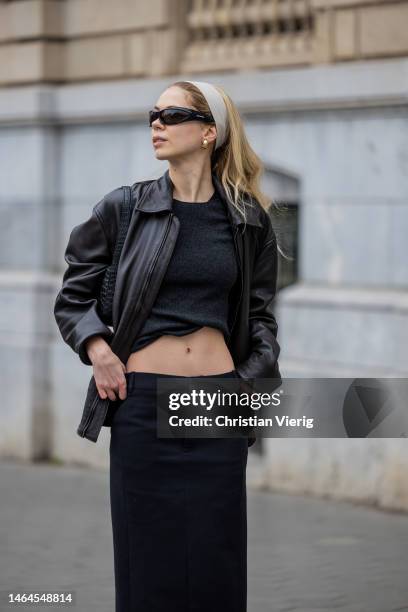 Ana wears black cropped top, leather jacket, black maxi skirt, hair band, ankle boots, Balenciaga sunglasses, YSL bag on February 08, 2023 in...