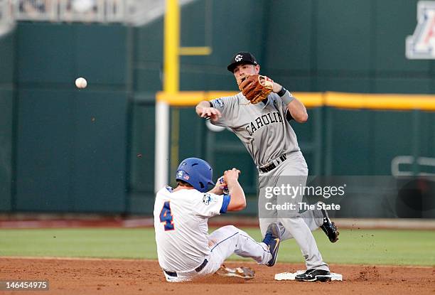 South Carolina's Joey Pankake turns a double play over Florida's Nolan Fontana in the first inning at the 2012 College World Series at TD Ameritrade...