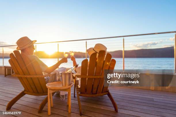 pareja relajándose y bebiendo vino y brindando en tumbonas - balcony view fotografías e imágenes de stock