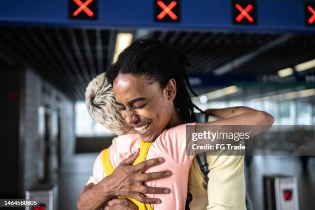 friends hugging each other in the subway station - real life friends stock pictures, royalty-free photos & images