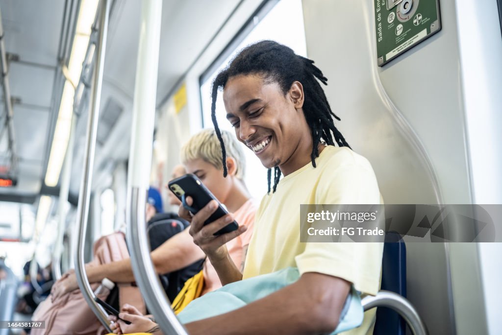 Young man using the mobile phone in the train