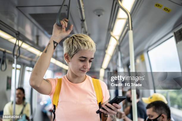 mulher nova usando o telefone celular no trem - metro transporte - fotografias e filmes do acervo