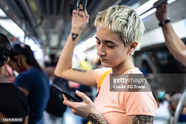 young woman using the mobile phone in the train - brazilian shorthair stock pictures, royalty-free photos & images