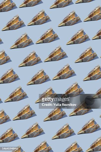 repeated 50 euro banknotes in shape of airplanes on the blue background - 50 euro stock pictures, royalty-free photos & images