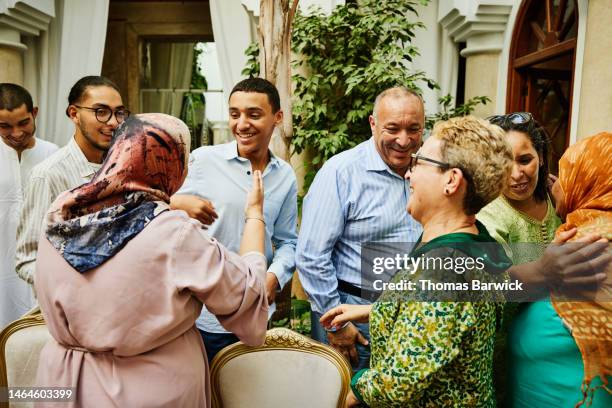 medium shot of smiling family arriving for celebration dinner - moroccan woman stock pictures, royalty-free photos & images