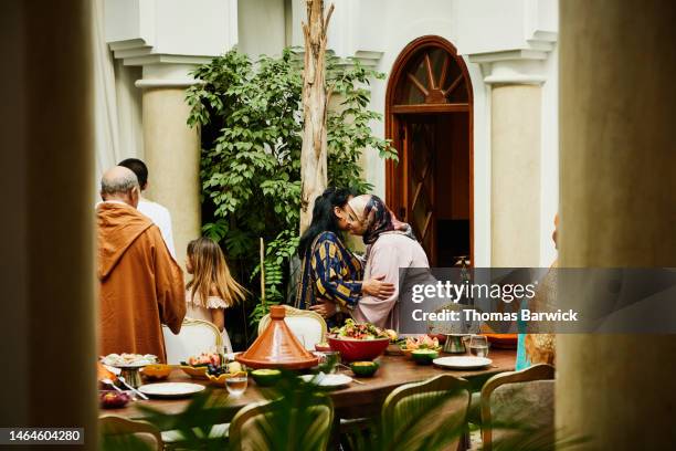 wide shot of family hugging and kissing while arriving for dinner - day celebration dinner arrivals stockfoto's en -beelden