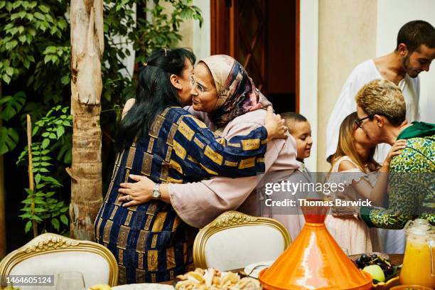 medium shot of mature women hugging while arriving for family dinner - religieuze apparatuur stockfoto's en -beelden