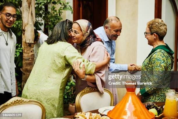 medium shot of mature women hugging while arriving for family dinner - north africa photos et images de collection