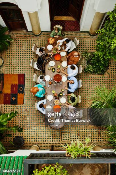 wide shot overhead view of family gathered for dinner celebration - arab family eating fotografías e imágenes de stock