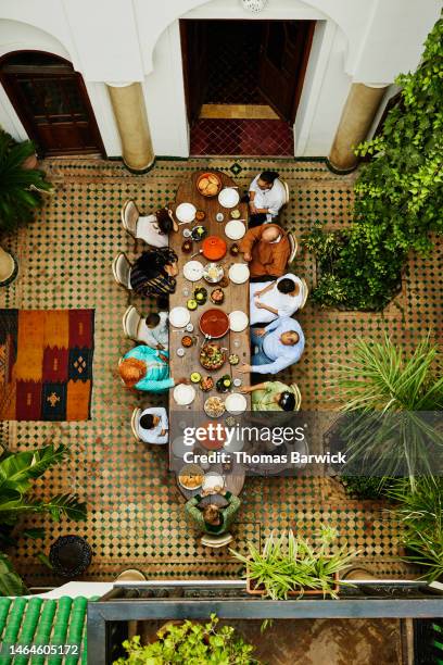 wide shot overhead view of family gathered for dinner celebration - arab family eating fotografías e imágenes de stock