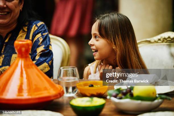 medium close up shot of young girl at dining room table during dinner - nordafrika stock-fotos und bilder